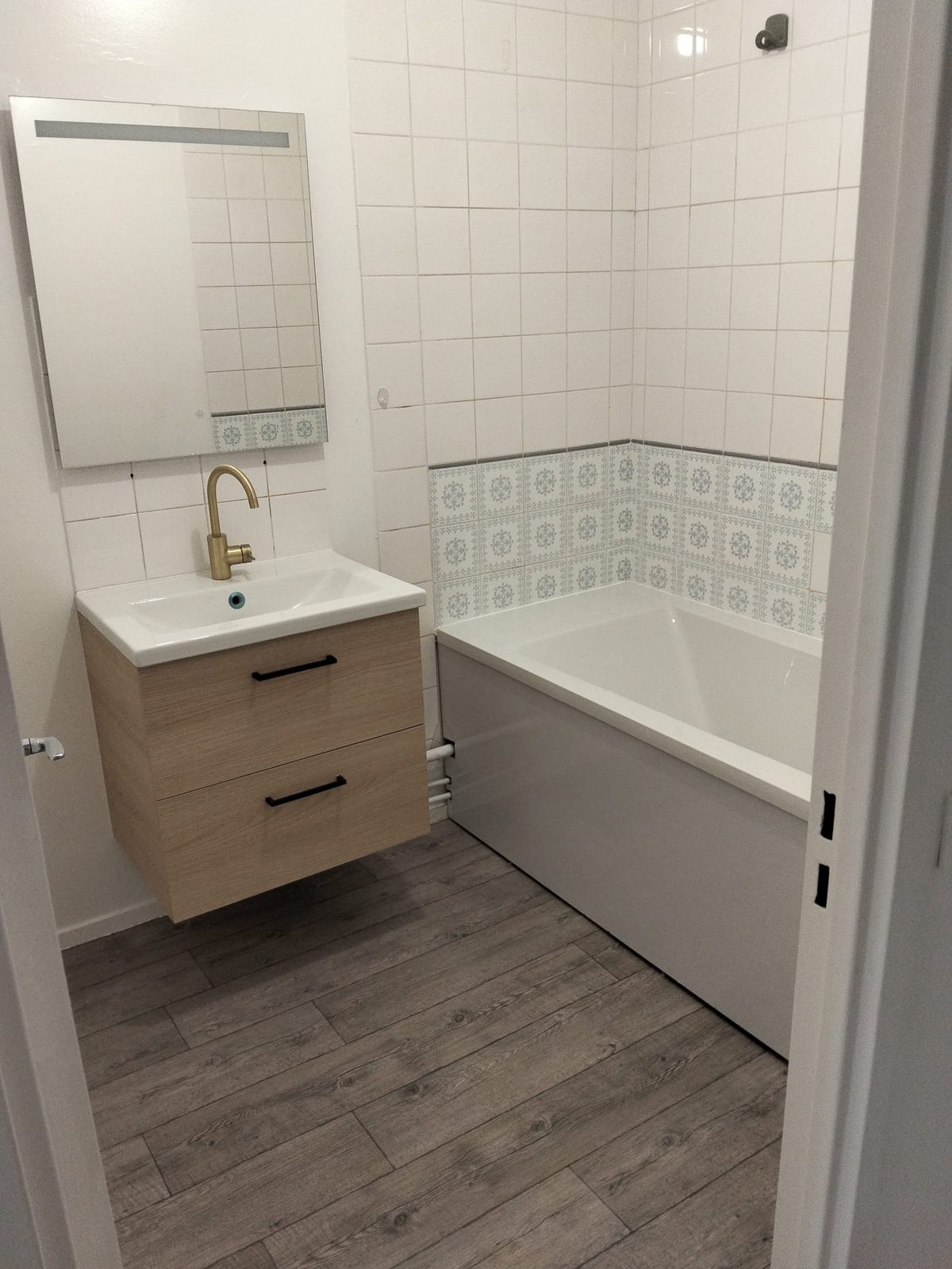 Salle de bains rénovée, baignoire et carrelage décoratif